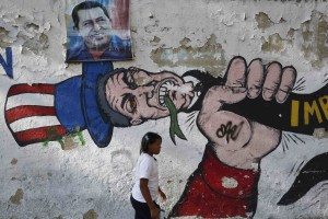 A woman walks past graffiti in Caracas